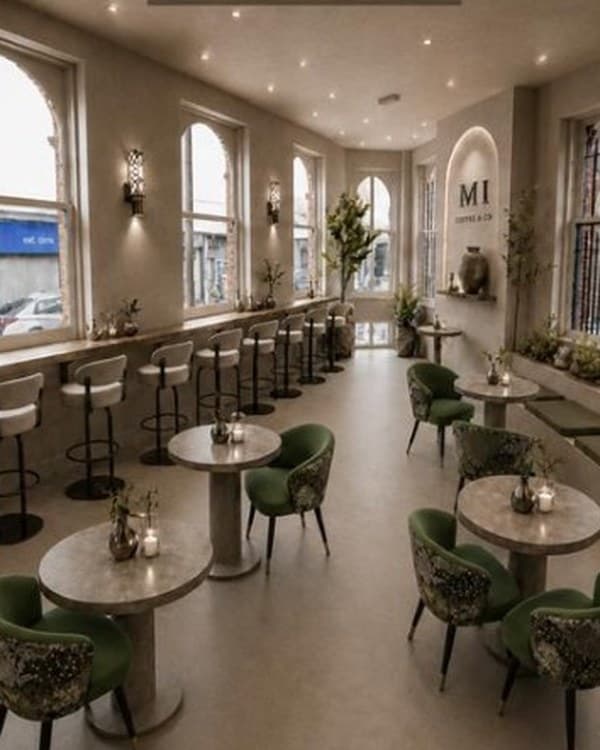 Interior concept: counter stools along arched windows, round stone tables and green velvet chairs, an alcove with the M1 mark
